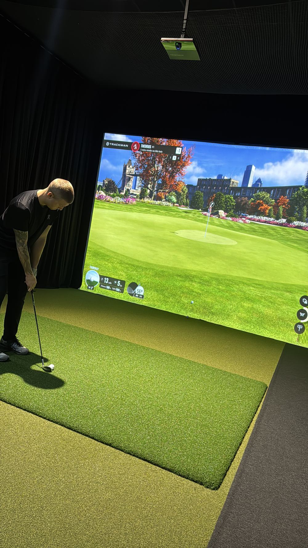 Golfer lining up a putt with a London course on screen at TOUR XP